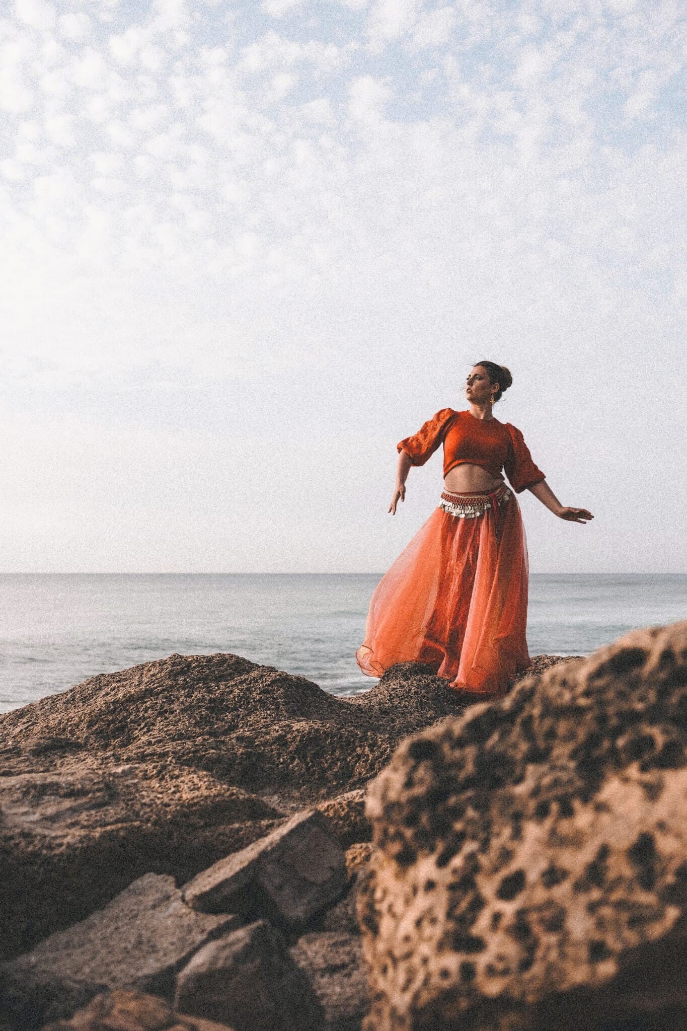 Woman performing oriental belly dance in orange dress during luxury women’s retreat in Morocco