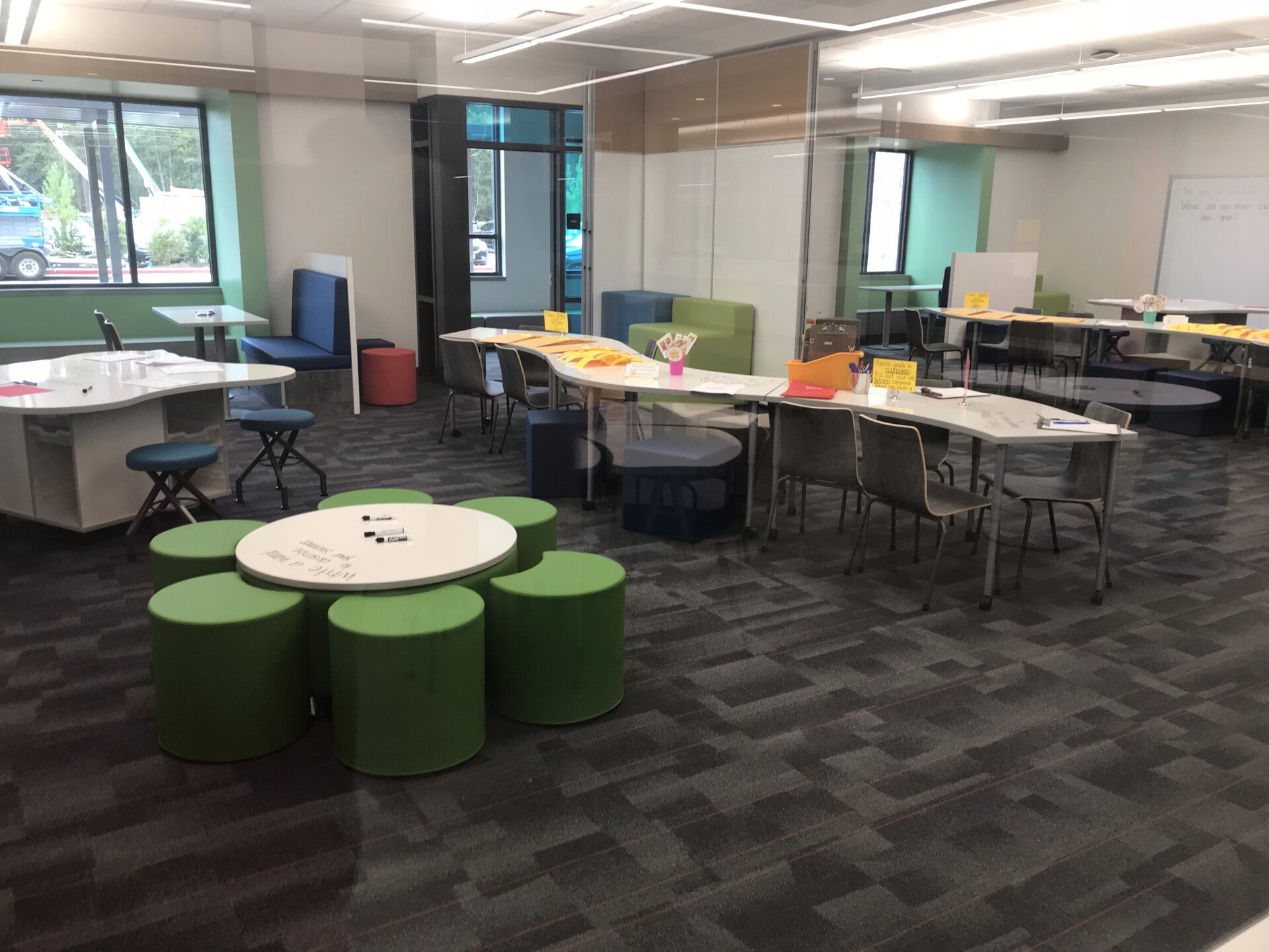 Installed desks, cabinets, shelving, chairs, and glass panels inside school classroom.