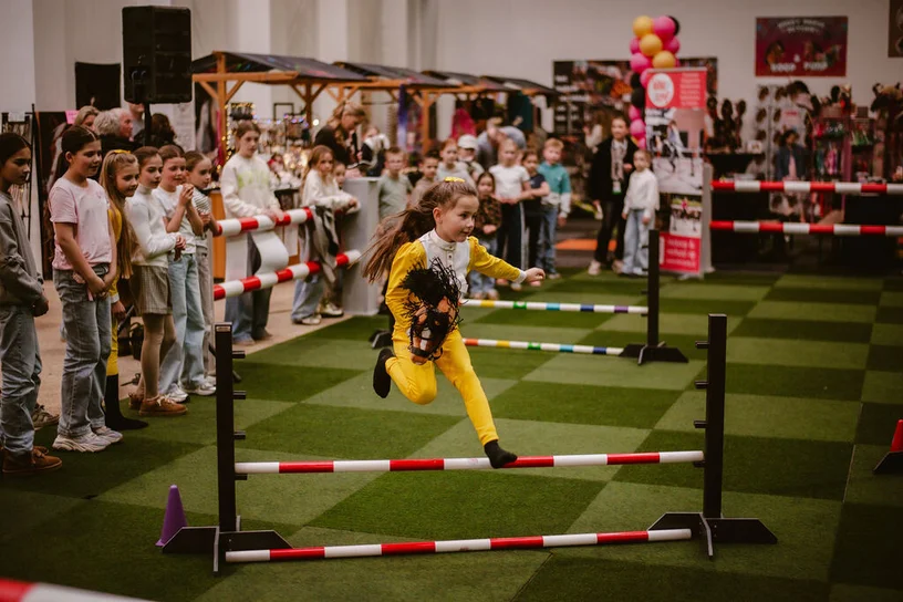 Kind springt tijdens een hobbyhorse wedstrijd