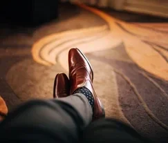 Close-up of a person's feet resting on a beautifully patterned carpet that dries quickly after professional cleaning, ensuring minimal downtime