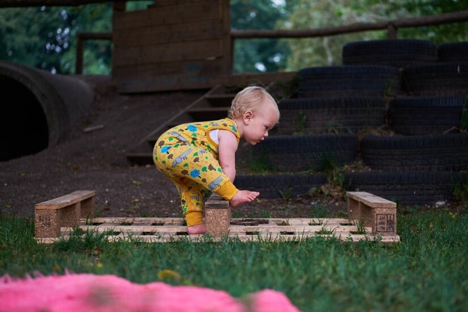 Baby dreumes klimt in speelgroep buiten