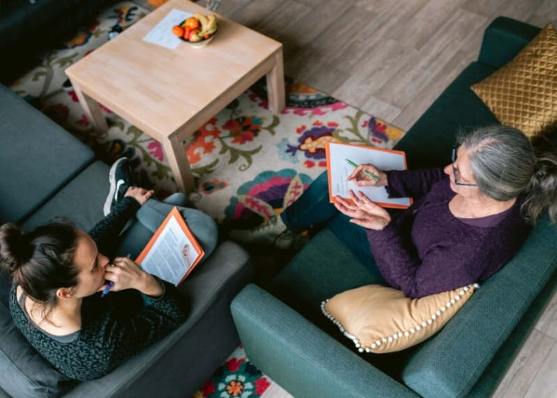 Docent en student op bank bij opleiding tot speelgroepbegeleider Visjeinhetwater