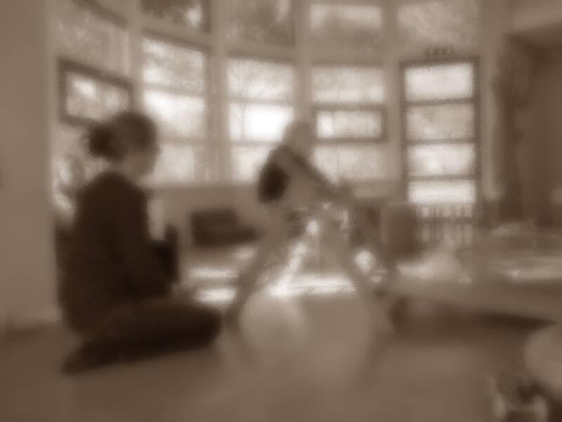 Vage foto van kind op klimrekje met begeleider ernaast