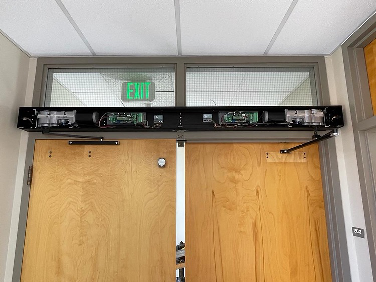 Automatic swing door with cover removed for servicing, showcasing internal components and repair work by California Automatic Doors (CAD). Expert service and repair for all makes and models of automatic swing doors, ensuring smooth operation and enhanced 