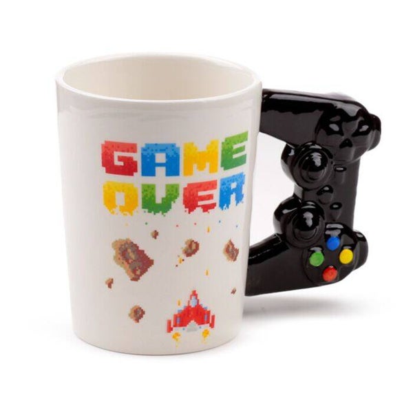 TAZA DE CERÁMICA ASA CON FORMA MANDO VIDEOJUEGO GAME OVER Y DIBUJO PÍXELES