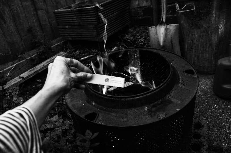 A medical wristband goes into the ceremonial fire 