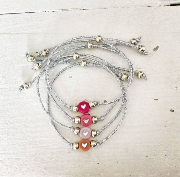 zilverkleurig stretch armbandje met roze hartje