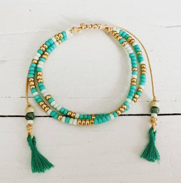 armbandje aqua- goud met kwastjes