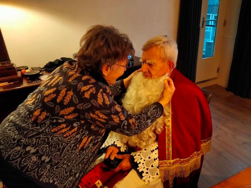 Riet Koevoets bezig met het aankleden van Sinterklaas