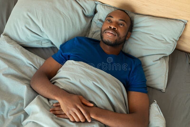 Mwanaume WA kiafrika akiwa macho kitandani Kwa kukosa usingizi WA usiku