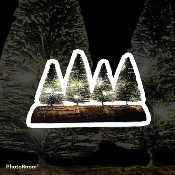 4 leuke kerstboompjes op een boomstronk met glitters.