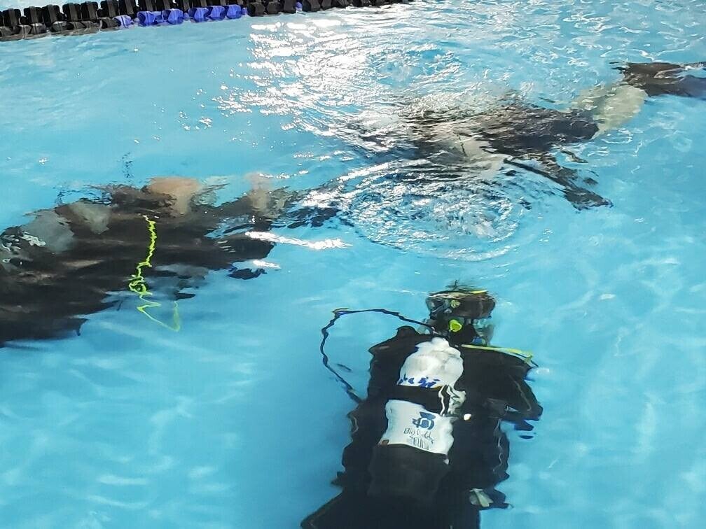 Two students and instructor underwater in during the confined water session of Basic Open Water