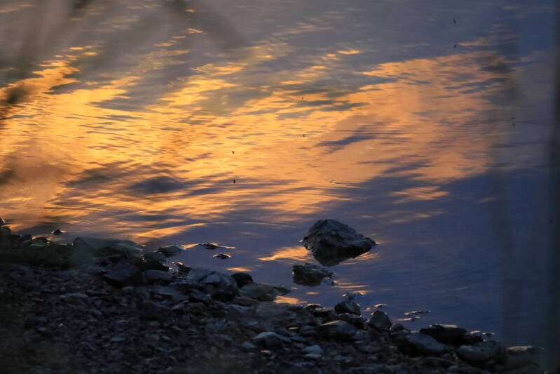 Stein im Wasser beim Sonnenuntergang