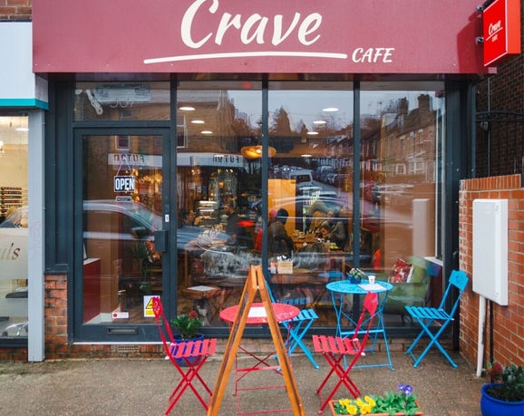 Crave Cafe shop front with tables and charis outside