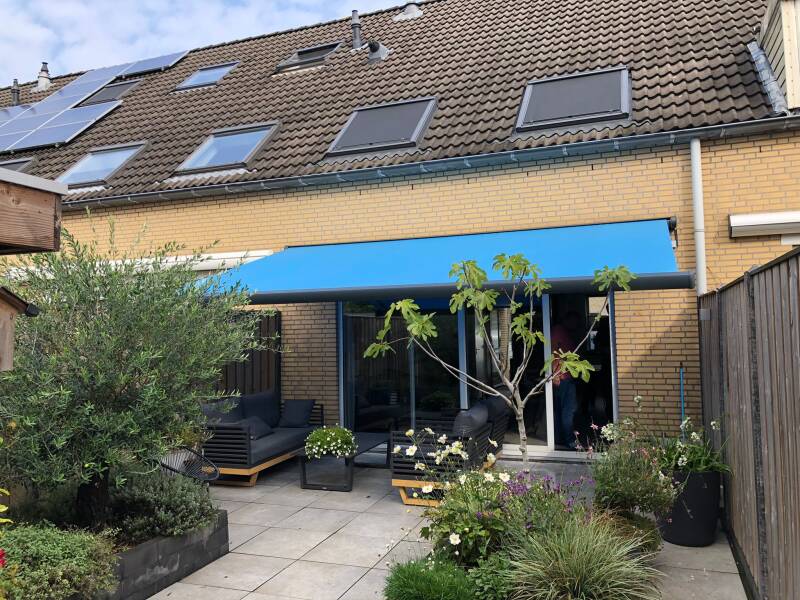 Hier een fraai knikarm zonne scherm Geplaatst met blauw doek