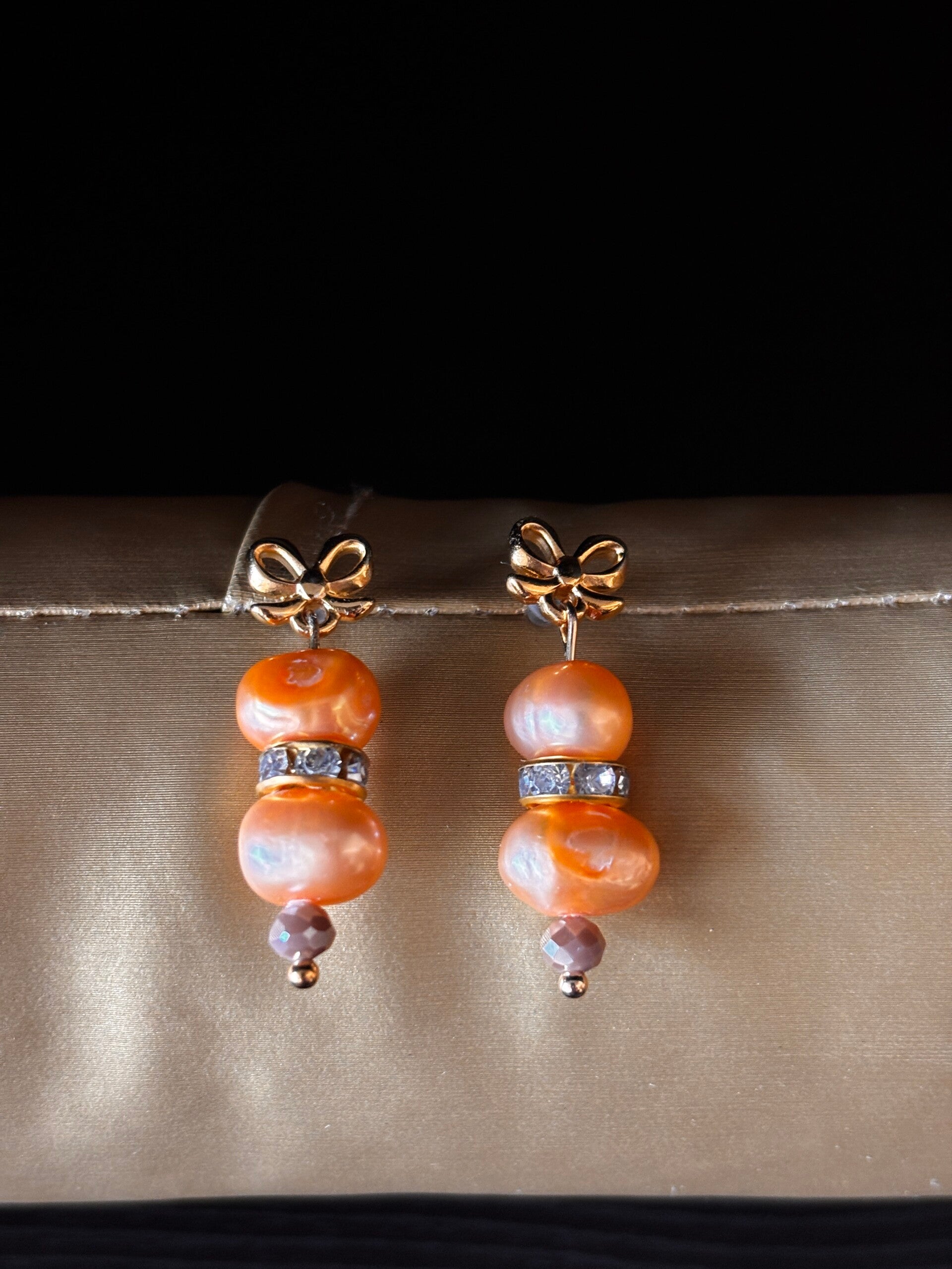 Luxe perzikkleurige parel oorbellen met goudkleurige strass spacer
