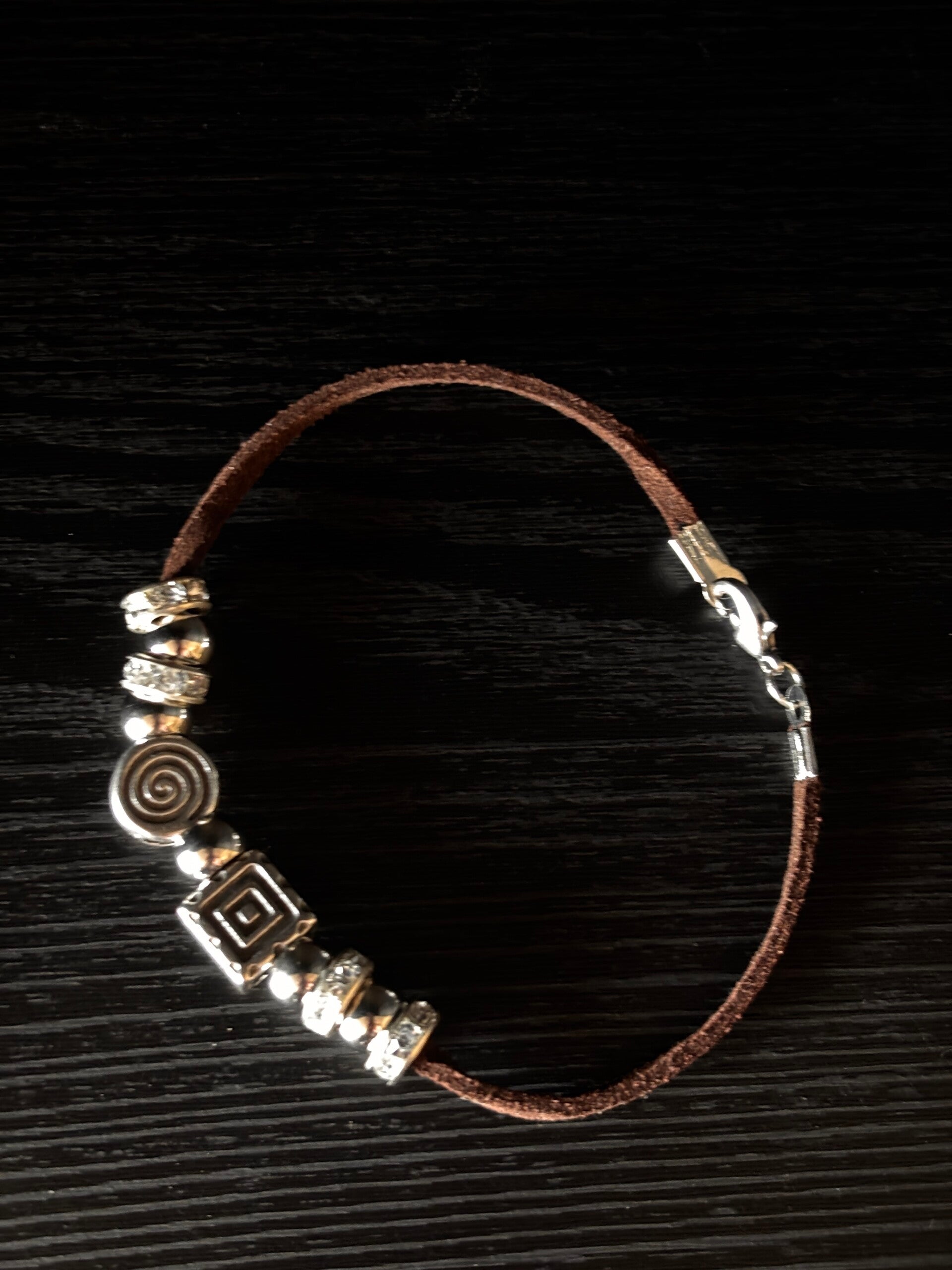 Bruin suede armbandje met verschillende zilveren bedels