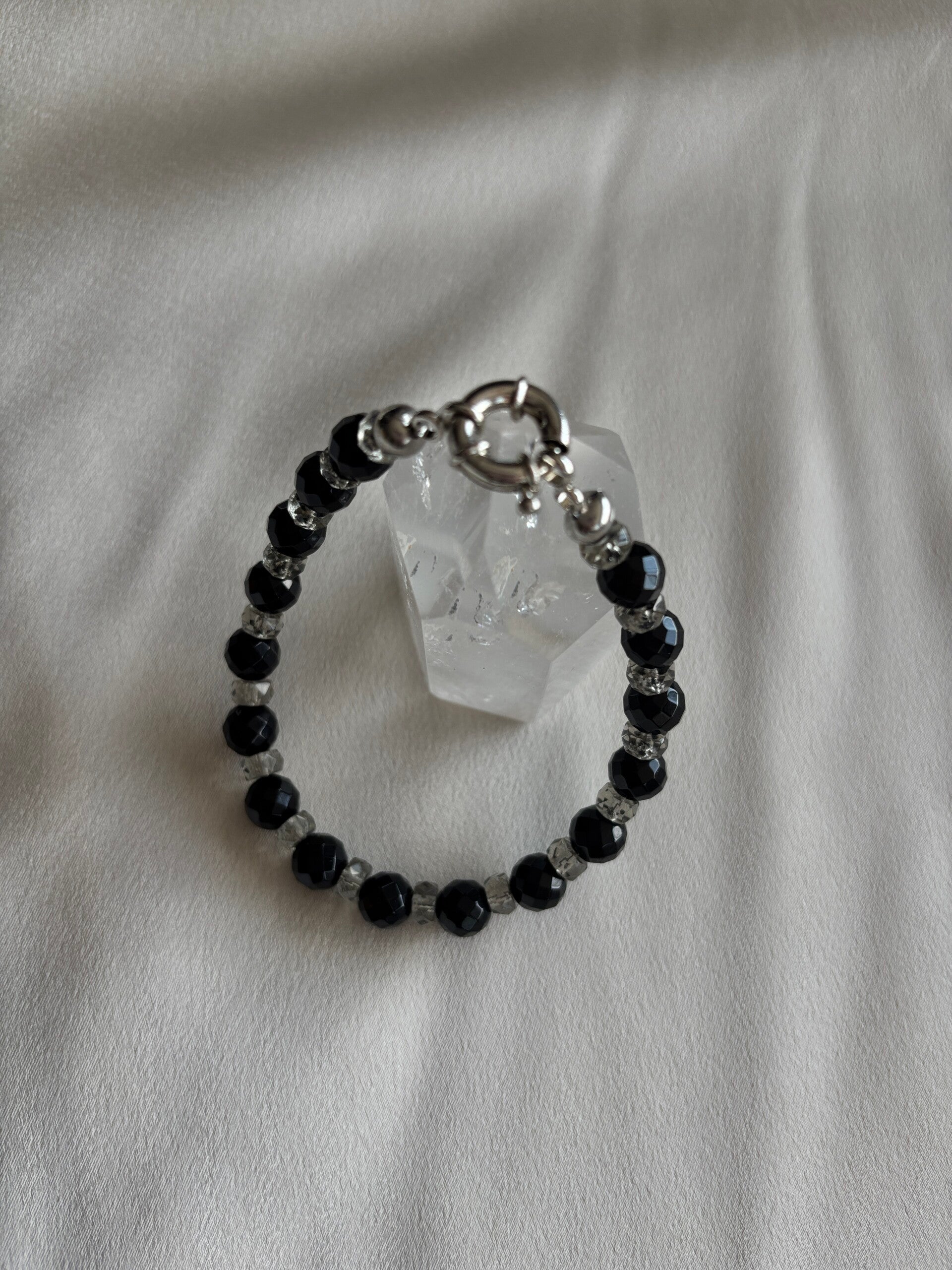 Onyx armband met grijze facetgeslepen spacers en zilveren boeislot