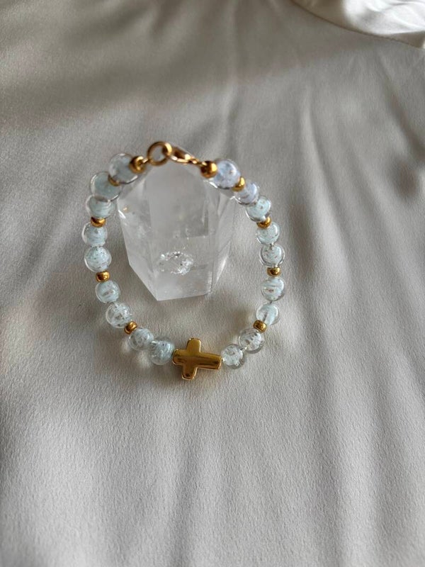 Witte murano glas armband met gouden bedel van een kruisje.