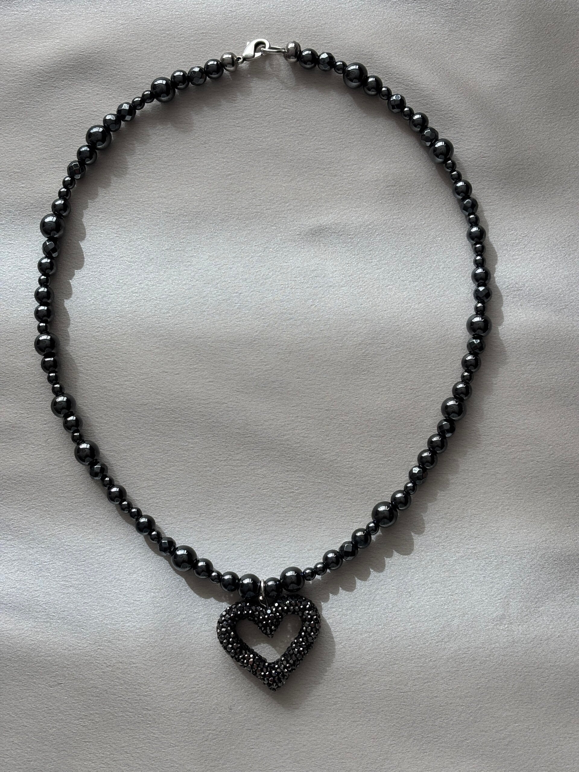 Zwart/grijs hematiet (edelsteen) ketting met een groot hart met zwarte strass steentjes.