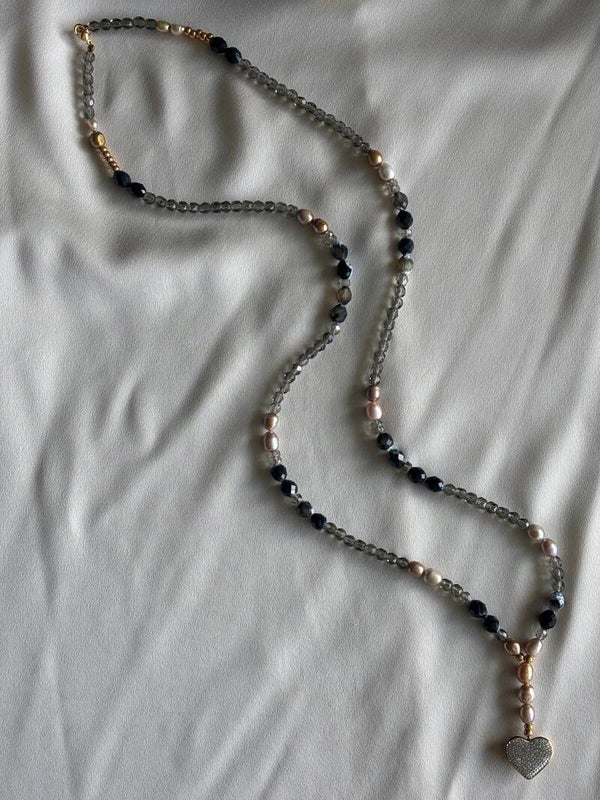 Lange statement ketting met goudkleurige parels, zwart/bruin agaat en Swarovski hart