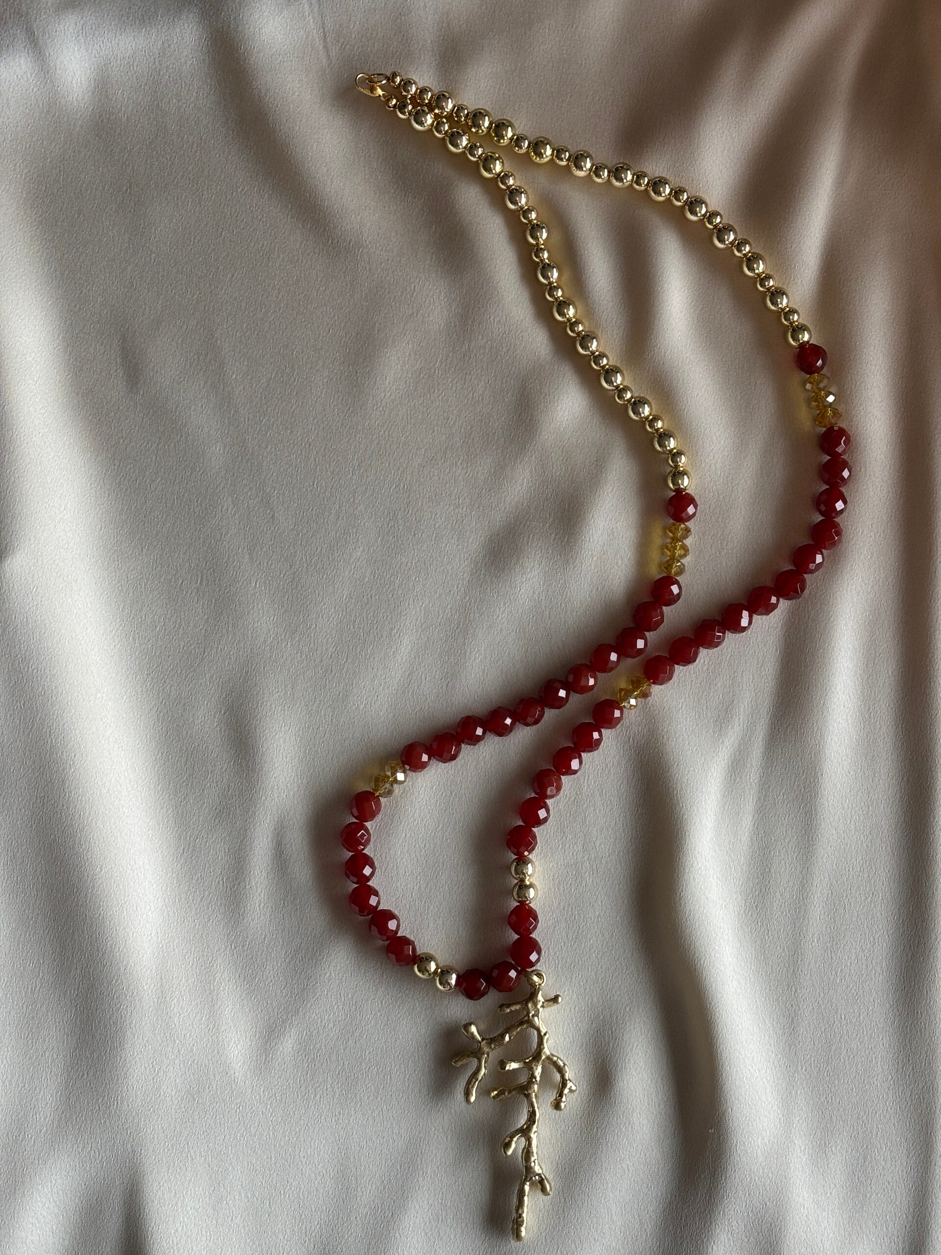 Lange ketting van Carneool en goudkleurige kralen met grote gouden hanger
