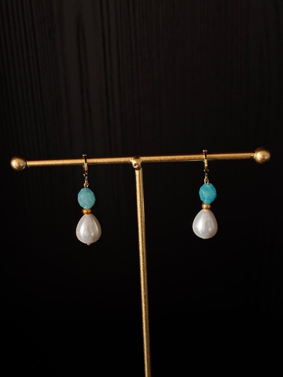 klassieke oorbellen van blauw jade en een kraal van schelp