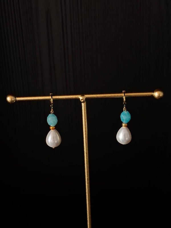 klassieke oorbellen van blauw jade en een kraal van schelp