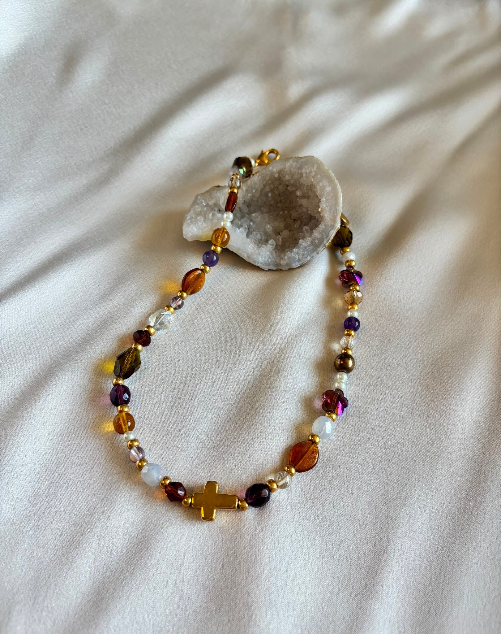 Ketting met diverse kleuren kralen en een goudkleurig kruisje