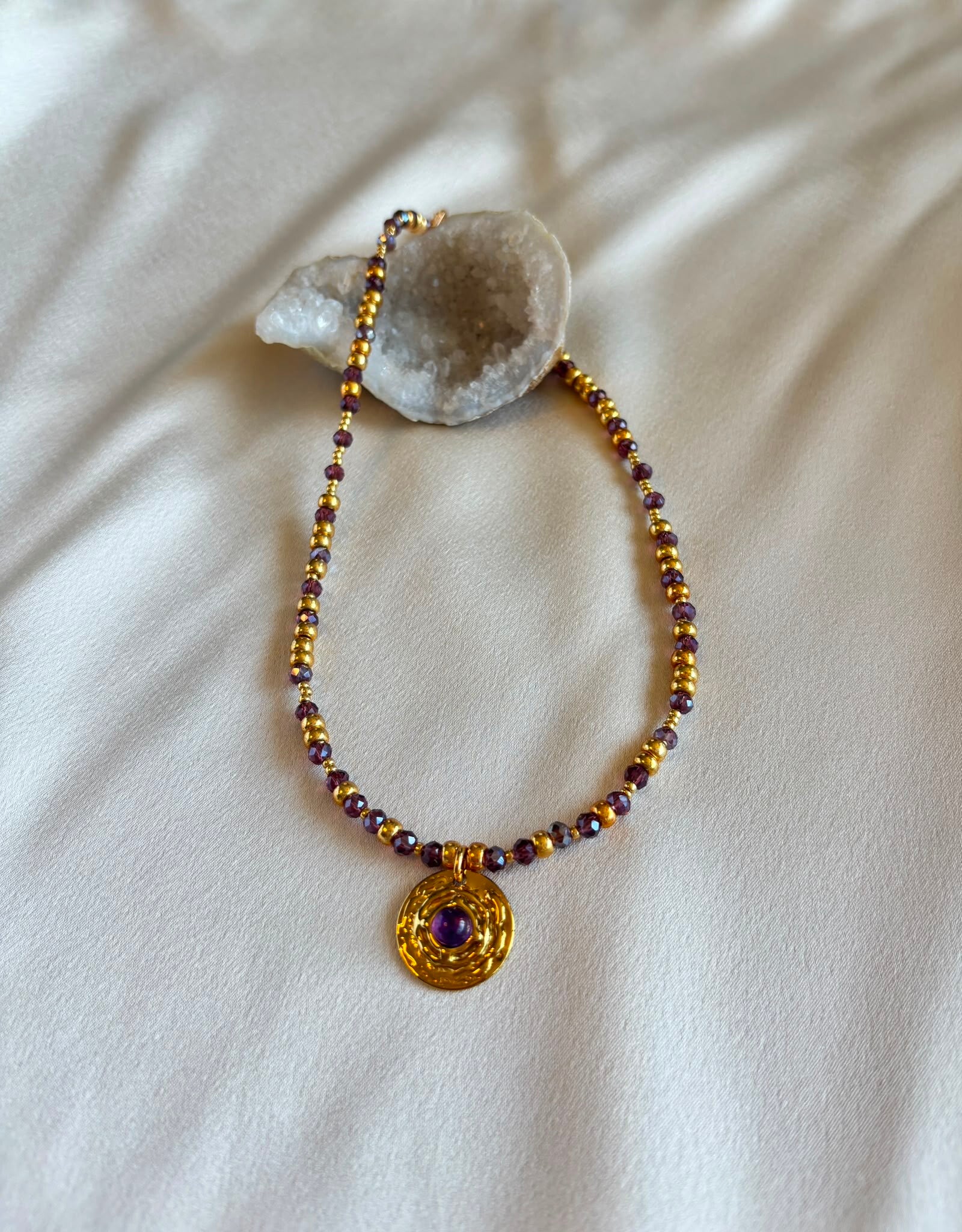 Goudkleurige ketting met Amethist bedel.