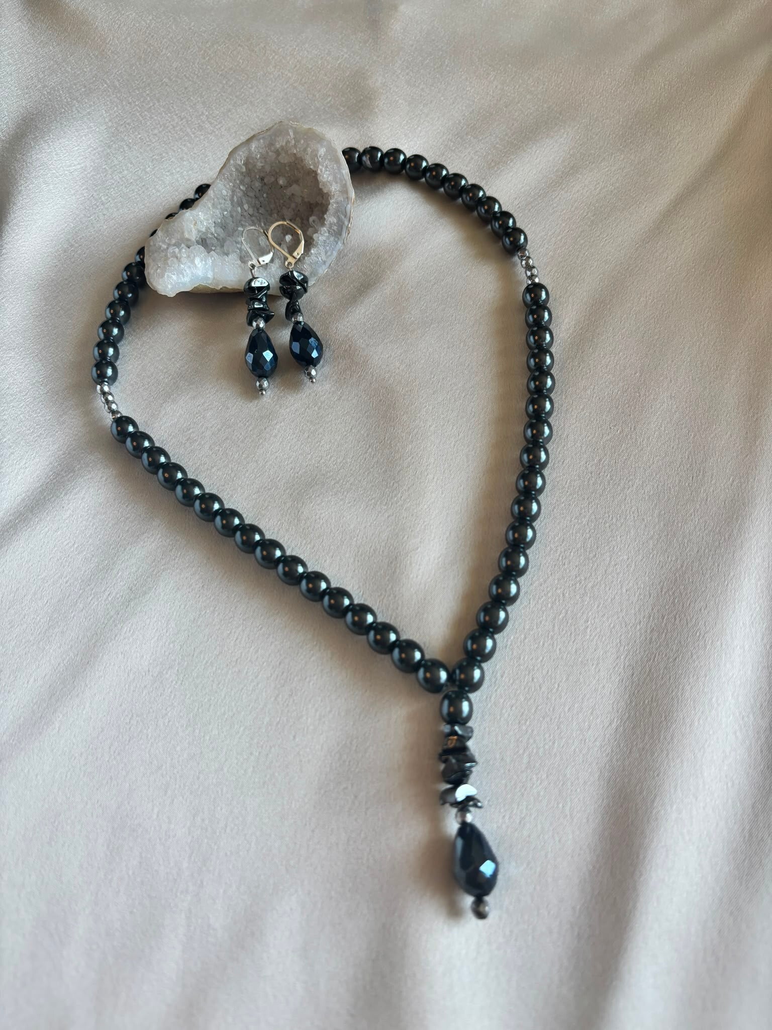 Ketting en oorbellen gemaakt van hematiet en flakes van onyx met een druppelhanger