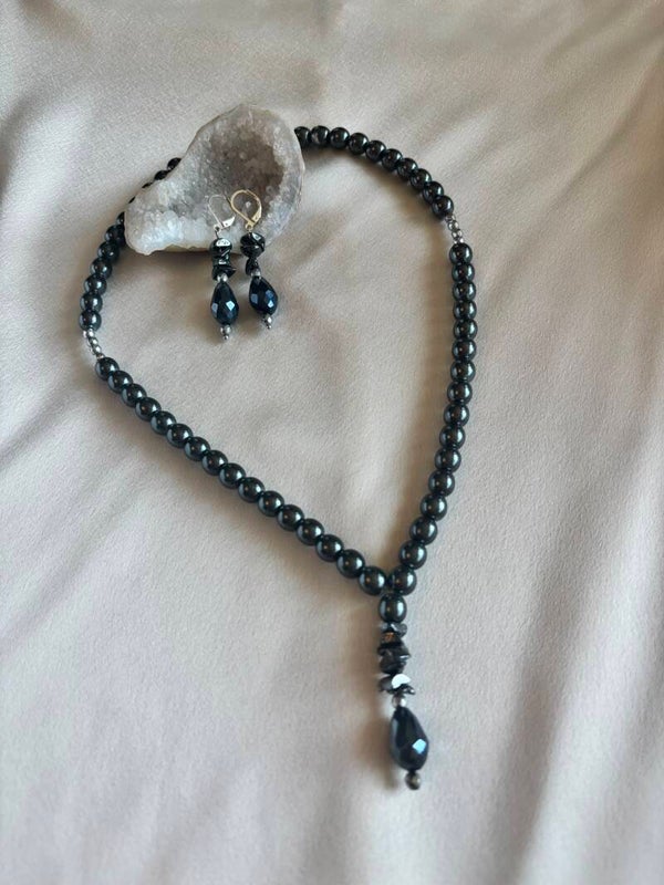 Ketting en oorbellen gemaakt van hematiet en flakes van onyx met een druppelhanger