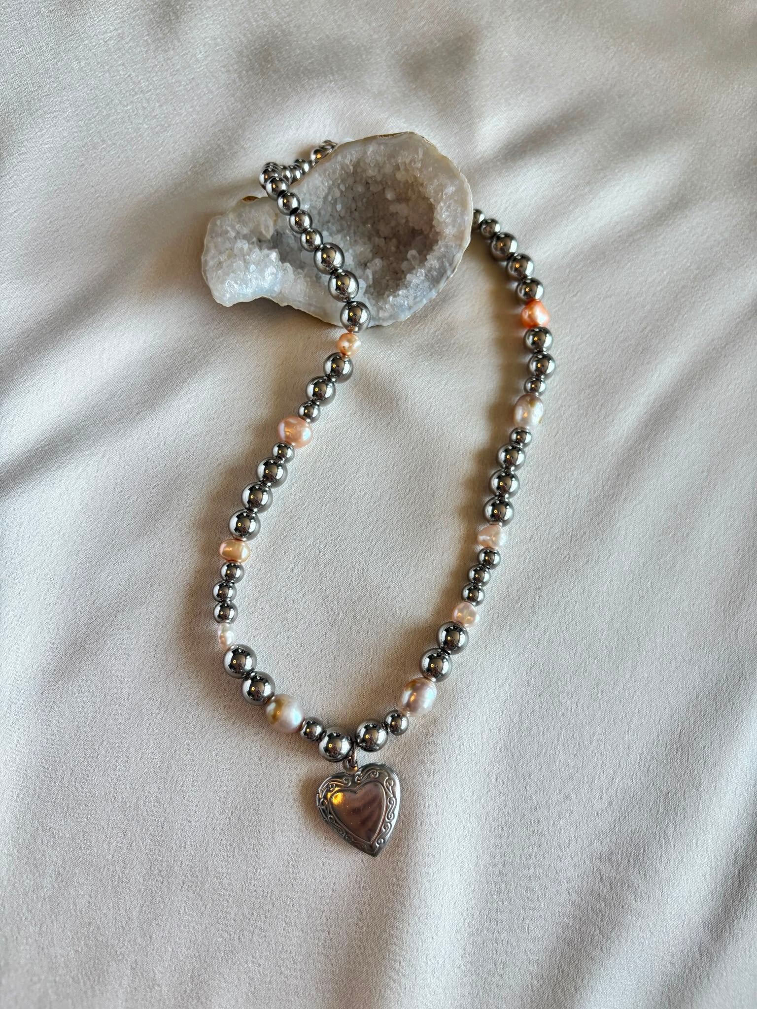 Zoetwaterparel met metalen kralen ketting en bedel van een hartje.