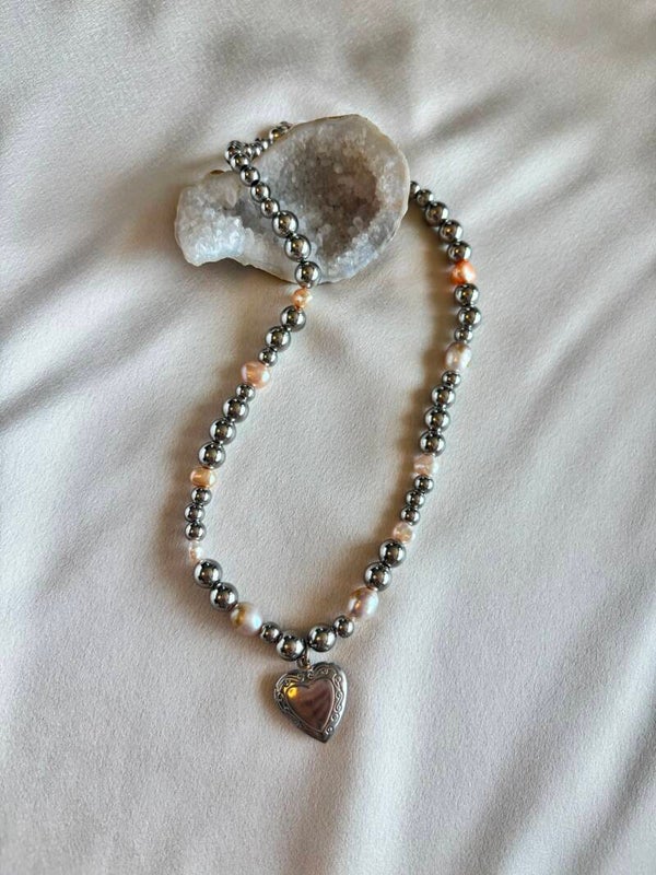 Zoetwaterparel met metalen kralen ketting en bedel van een hartje.