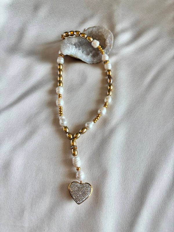 Ketting van zoetwaterparels, gouden glasparels met een hart bedel van Swarovski steentjes.