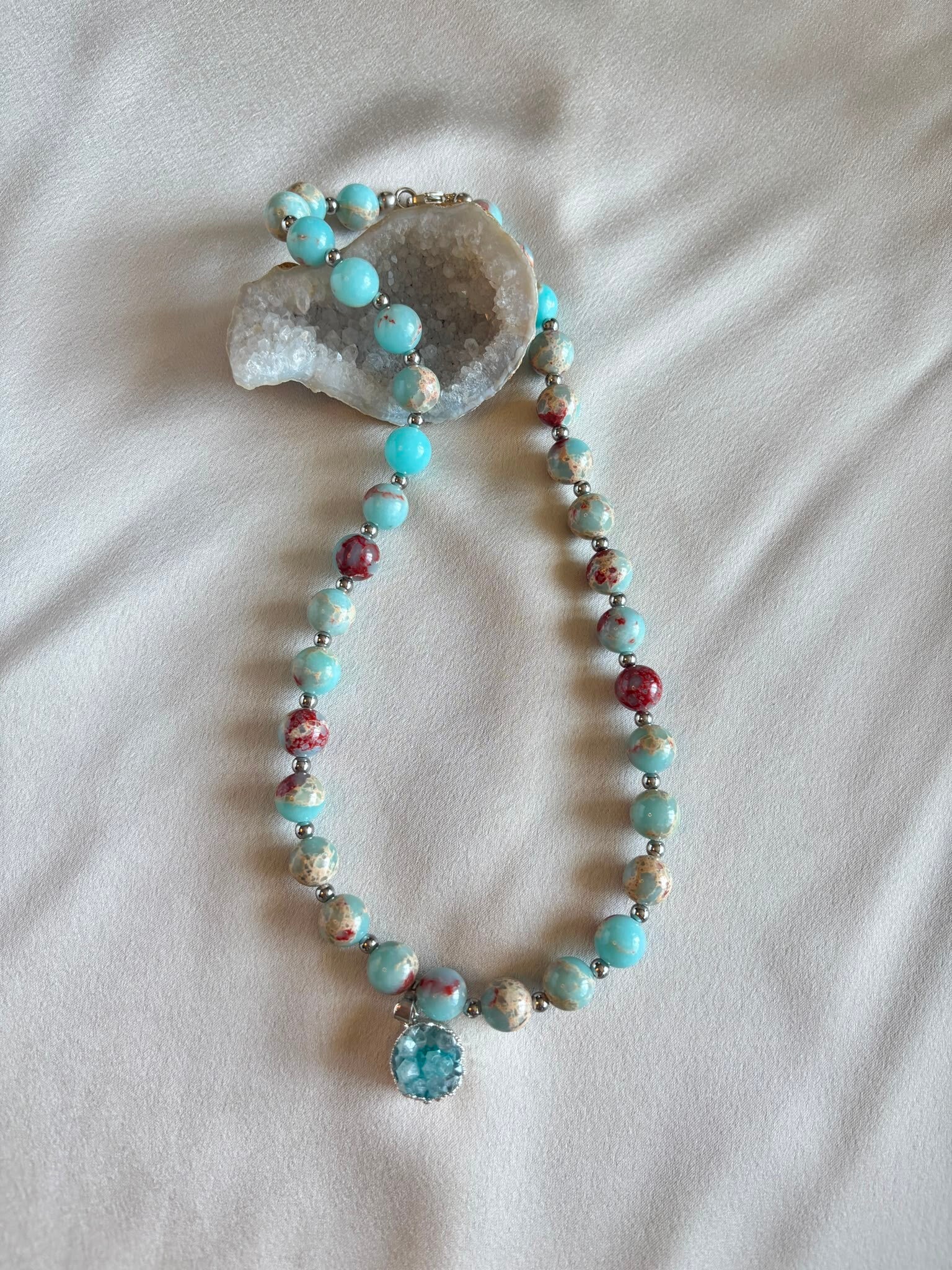 Bijzondere ketting van groene snake stone met een lichtblauwe hanger van agaat.