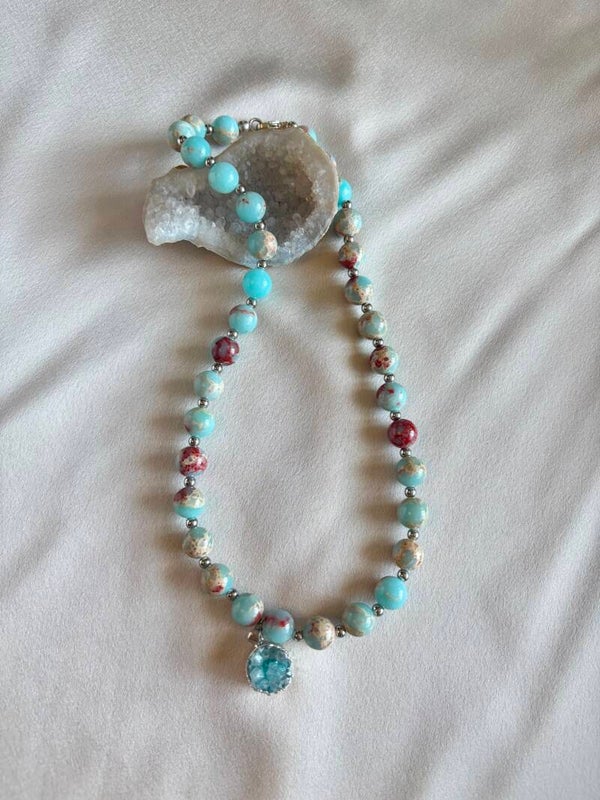 Bijzondere ketting van groene snake stone met een lichtblauwe hanger van agaat.