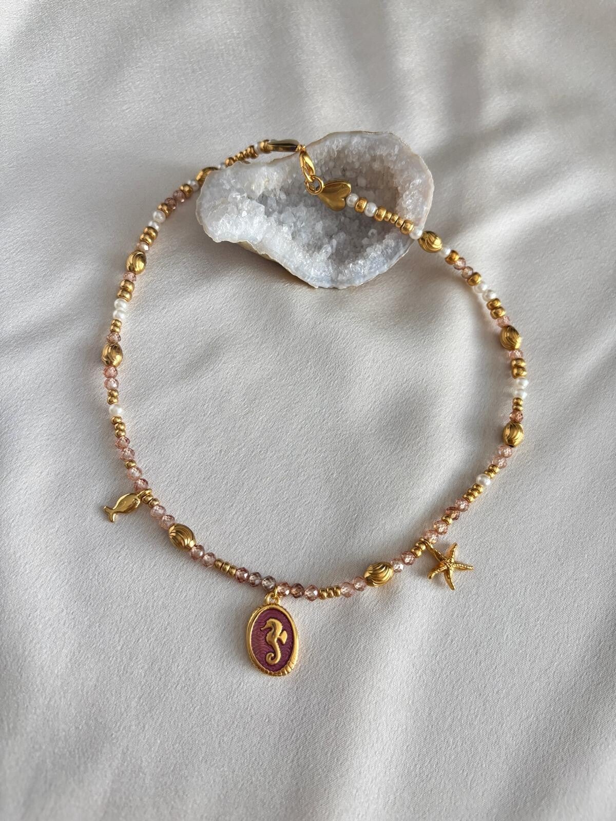 Bedelketting met gouden kralen en roze facetkralen