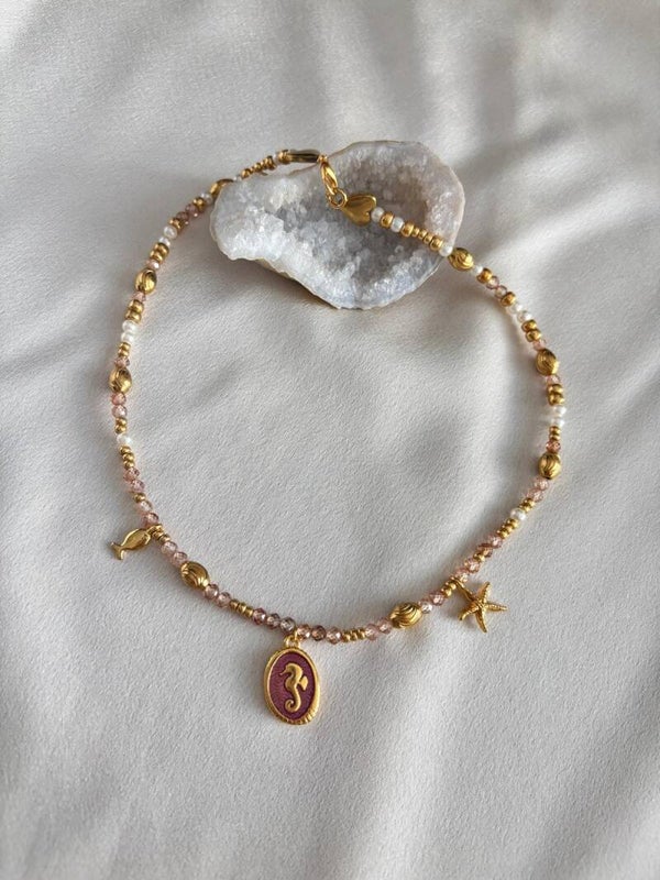 Bedelketting met gouden kralen en roze facetkralen