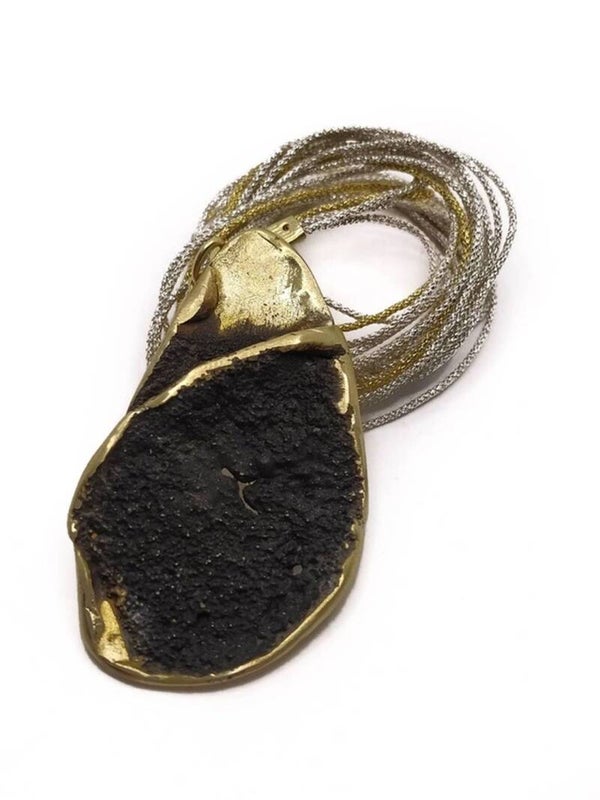 Elegante collar con forma de hoja de bronce en negro.