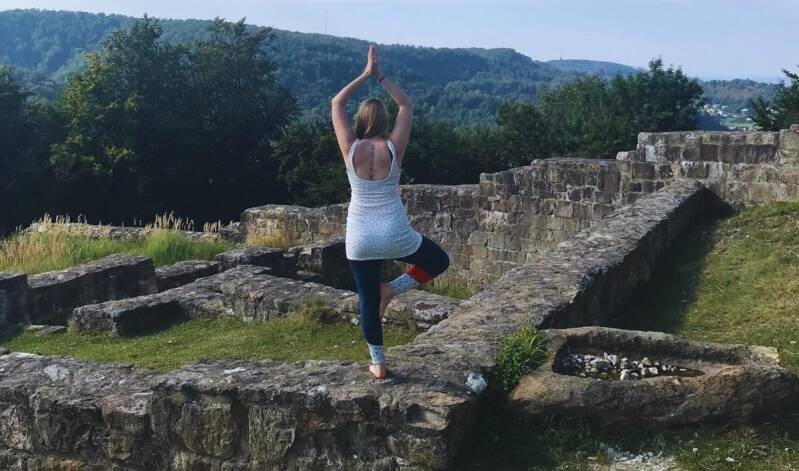 Maike praktiziert Yoga in der Baumhaltung auf der Falkenburg