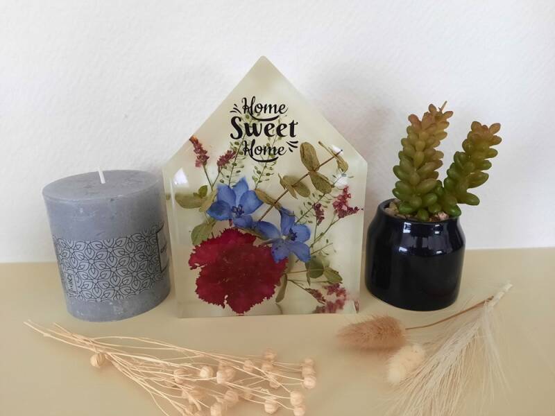 huis van epoxy met hierin droogbloemen verwerkt op een witte achtergrond