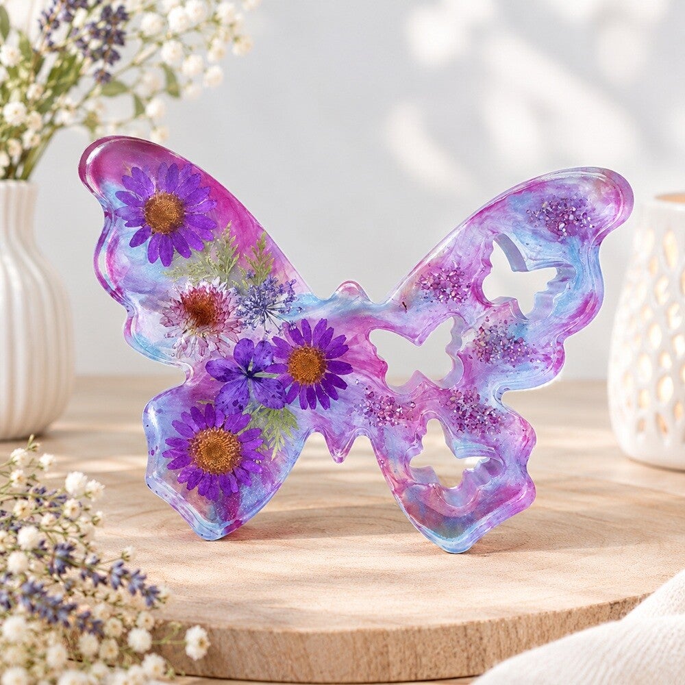 Epoxy vlinder met paars-blauw marmerpatroon en droogbloemen.