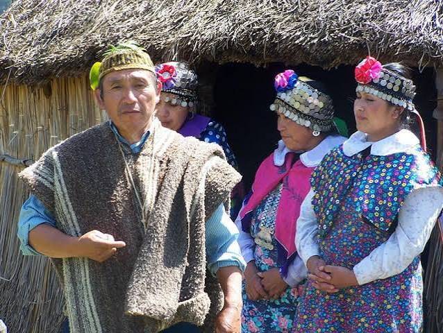 Drei Frauen und ein Mann in tradtioneller Mapuche Kleidung Chile