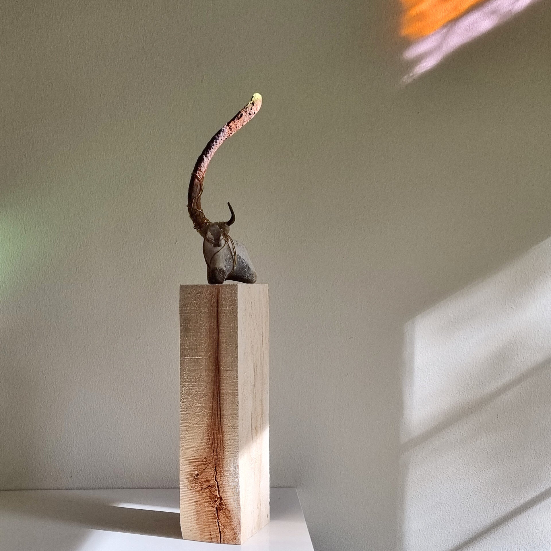 Found object art Taurus of flint, old iron, beeswax and brass wire on a pinewood pedestal