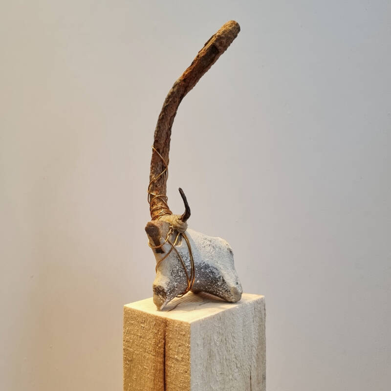 Found object art Taurus van vuursteen, oud ijzer, bijenwas en messingdraad op een vurenhouten sokkel