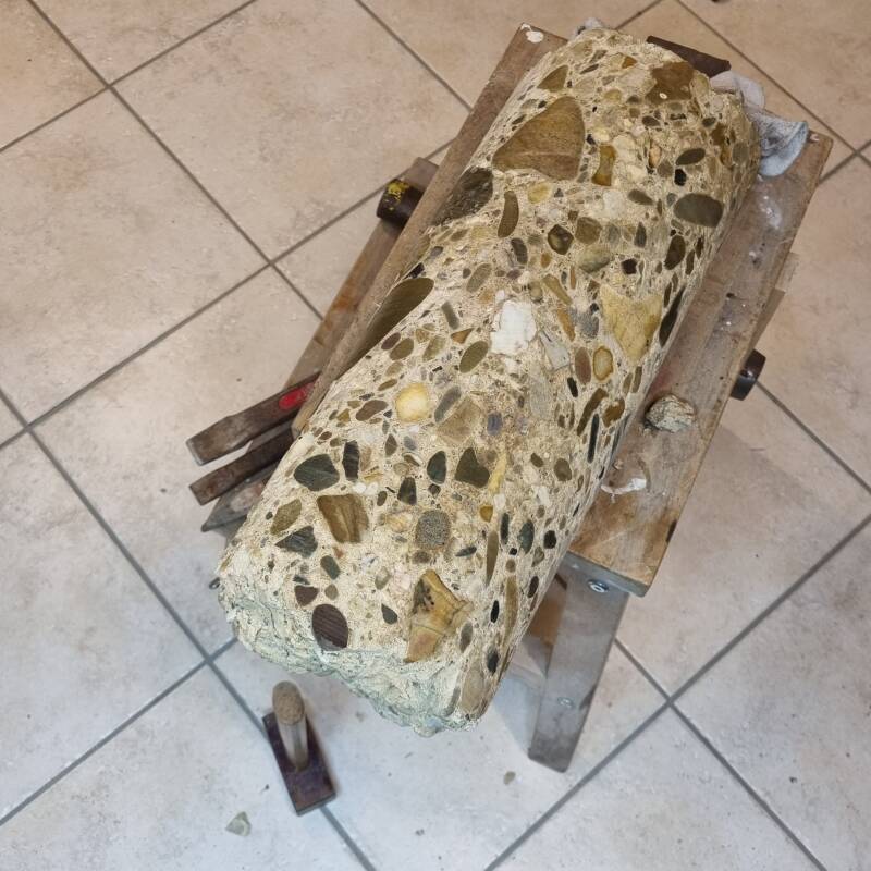 A concrete drill core from a foundation with visible pebbles