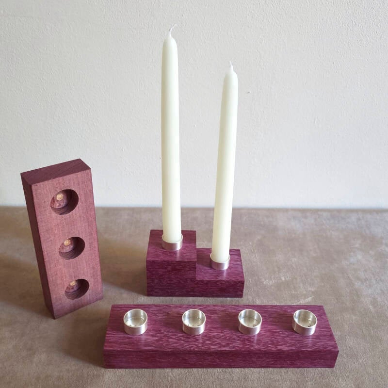 three candlesticks made of purpleheart wood and Argentium silver that can form a Hanukkiah as well as other forms