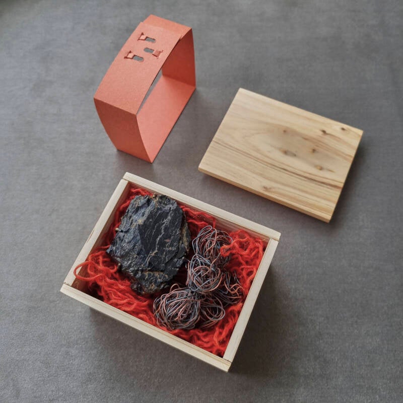 Prijzenwinnende broche en de bijbehorende doos van koper en ijzerdraad, die mijn grootvader, een mijnwerker, en mijn gedisciplineerde grootmoeder voorstelt, met zes metalen balletjes die hun kinderen symboliseren.