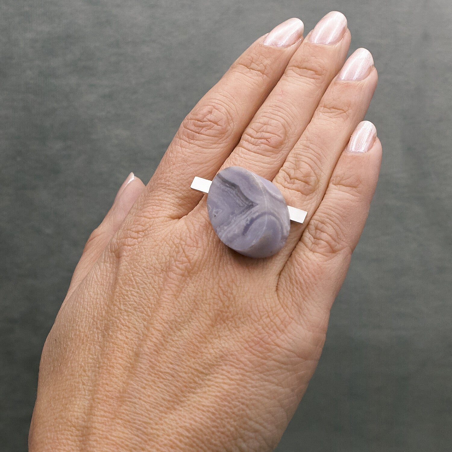 hand met zilveren ring met calcedon